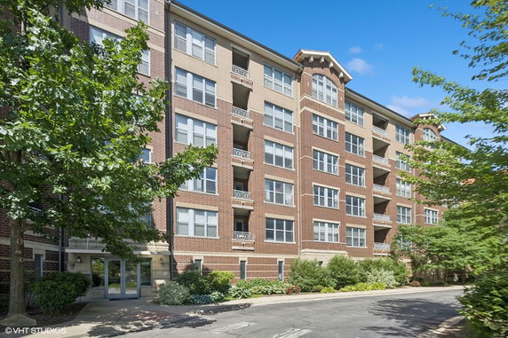 Front view of a multi-story apartment building with brick exterior.