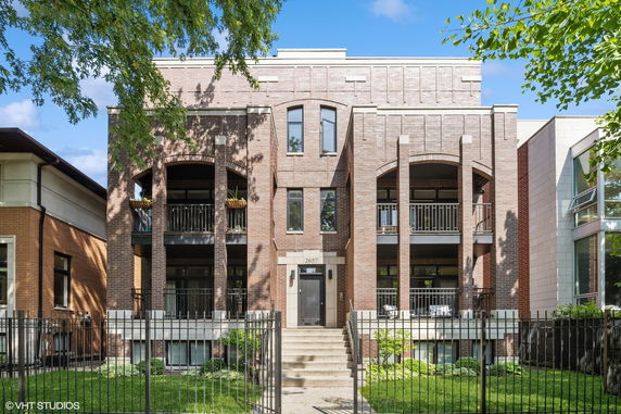 Front view of a modern multi-story building with brick facade and balconies.