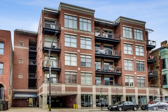 Front view of a multi-story brick building with balconies.