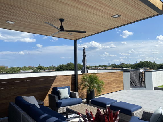 Rooftop patio with outdoor seating and ceiling fan.