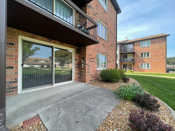 Front view of a brick apartment building with multiple stories and balconies.