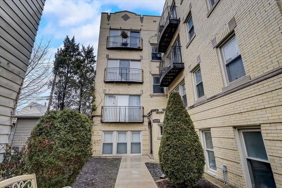 Front view of a multi-story apartment building with balconies.