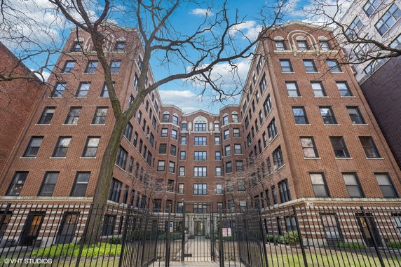 Front view of a multi-story brick building with symmetrical design.