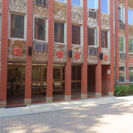 Front view of a building with red brick facade and decorative features.
