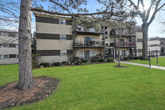 Front view of a multi-story apartment building with balconies.