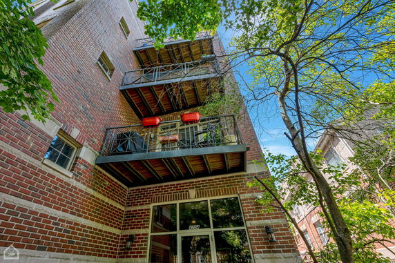 Elevated view of a multi-story brick building with balconies.
