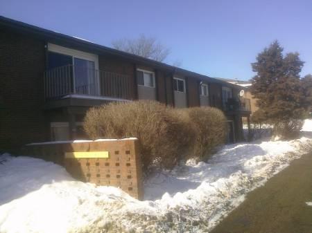 Front view of a residential building with balconies and snow-covered surroundings.