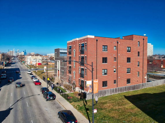 Front view of a multi-story brick building on a city street.