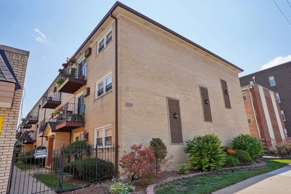 Front view of a three-story apartment building with balconies.