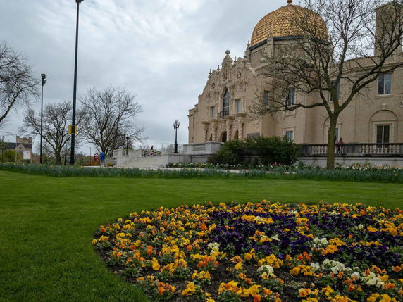 Front view of a building with a golden dome and ornate architectural details.