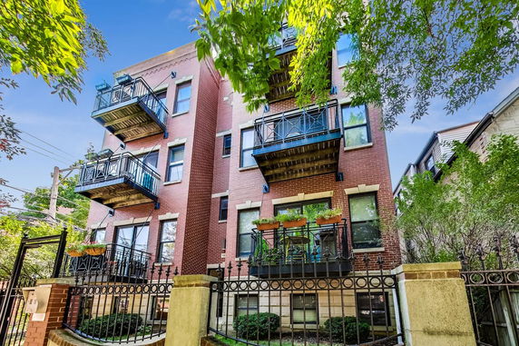 Front view of a brick apartment building with balconies.