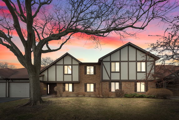 Front view of a two-story house with Tudor-style architecture and a two-car garage.