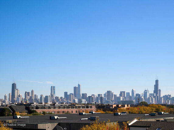 Panoramic view of a city skyline with tall buildings under a clear blue sky.