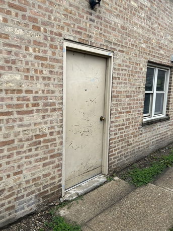 Brick wall with a closed door and window.