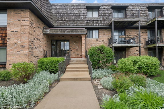 Front view of a multi-story brick building with balconies.