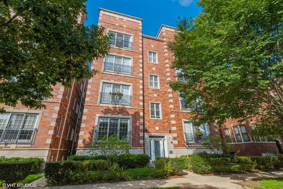 Front view of a multi-story building with brick facade and large windows.