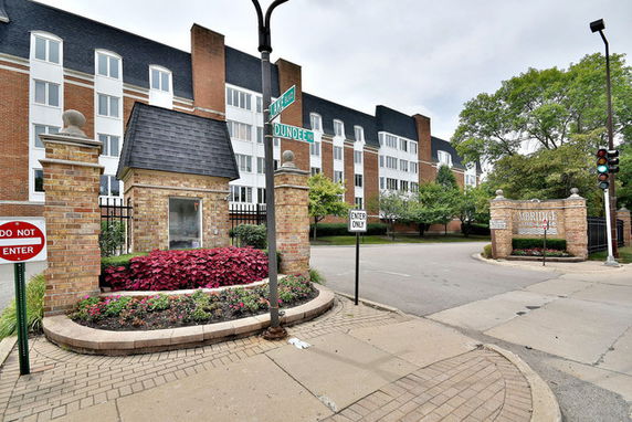 Front view of a multi-story residential building with brick and white facade.