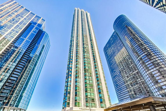 Front view of a tall high-rise building with glass windows, flanked by two other tall buildings.