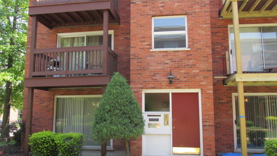 Front view of a brick multi-story building with balconies.