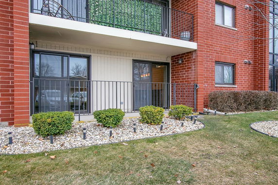 Front view of a multi-story building with balconies and sliding glass doors.