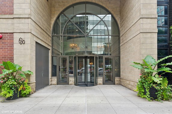 Entrance of a building with large glass doors and brick facade.
