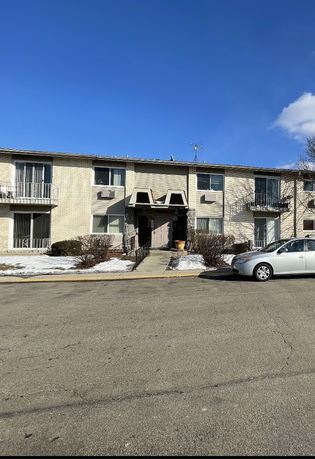 Front view of a two-story apartment building with multiple balconies.