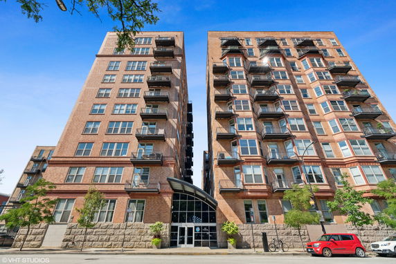 Front view of a multi-story brick building with balconies.