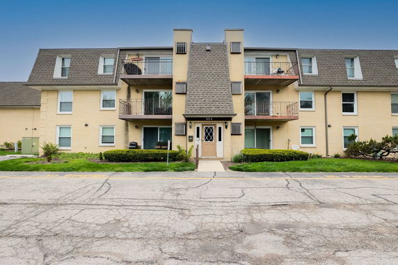 Front view of a two-story apartment building with balconies.