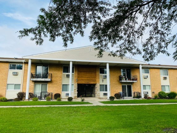 Front view of a two-story building with balconies and a central entrance.