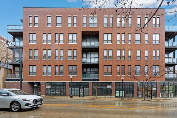 Front view of a multi-story brick building with numerous windows and balconies.