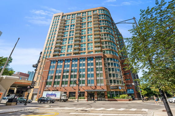 Front view of a multi-story building with a curved facade and multiple balconies.