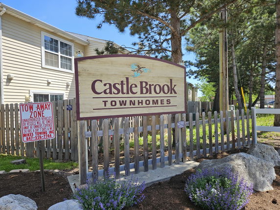 Front view of a townhome building with signage.