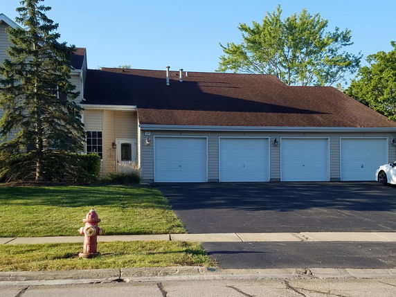 Front view of a house with a large garage featuring multiple doors.