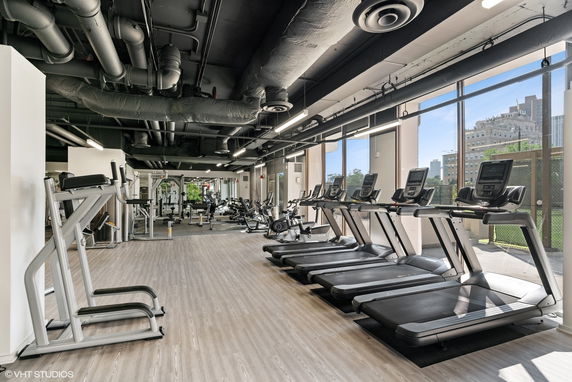 Interior of a gym with exercise equipment and treadmills.