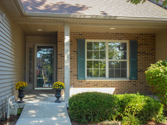 Front view of a house with a brick facade and a small entrance porch.