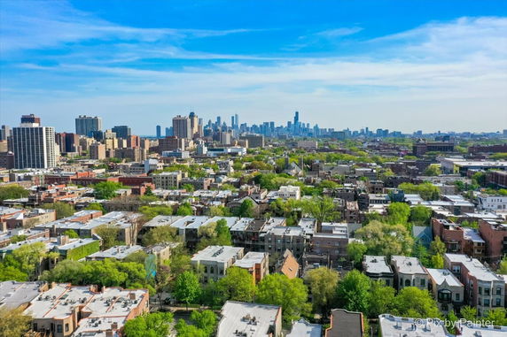 Panoramic view of a city skyline and surrounding residential buildings with greenery.
