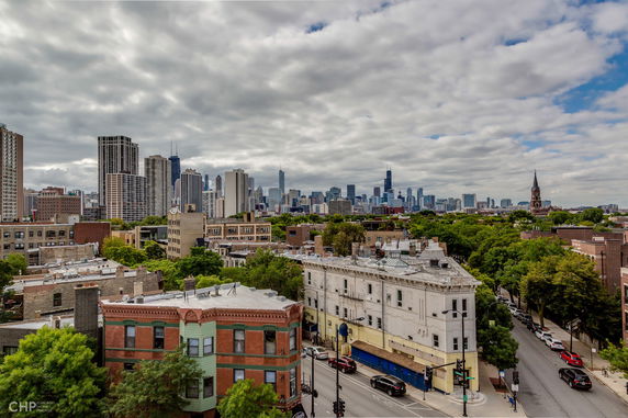 Panoramic view of a cityscape with tall buildings and tree-lined streets.