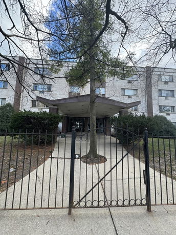 Front view of a multi-story building with a gated entrance.