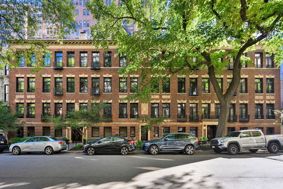 Front view of a multi-story brick apartment building with large windows.