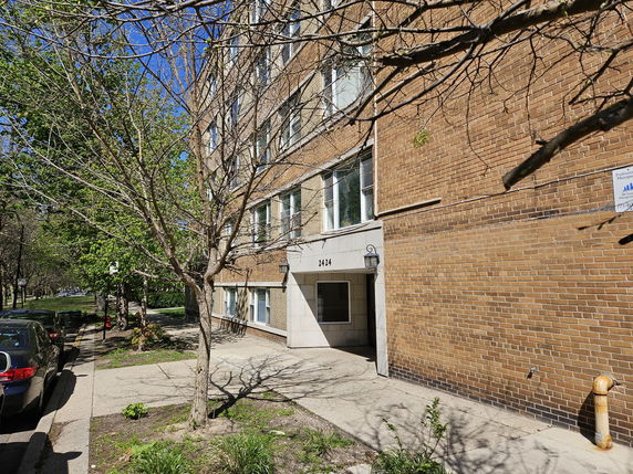 Front view of a multi-story brick building with entrance.