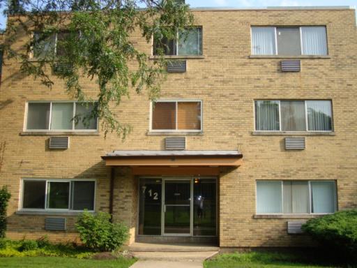 Front view of a three-story brick apartment building with multiple windows.