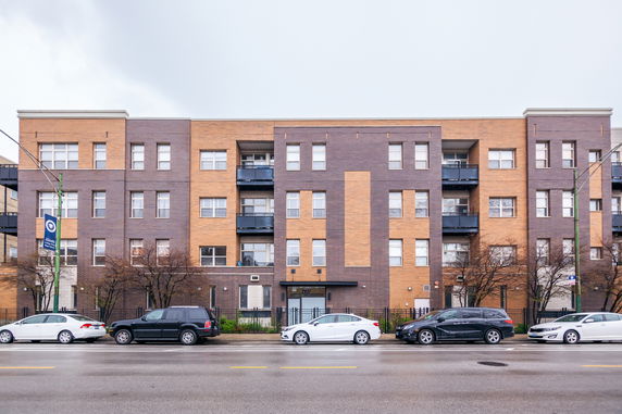 Front view of a multi-story apartment building with brick facade.