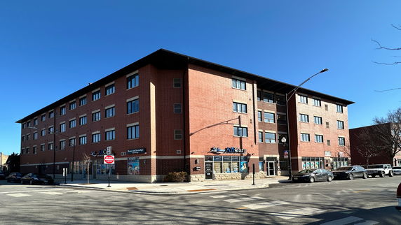 Front view of a multi-story brick building with street-level commercial spaces.