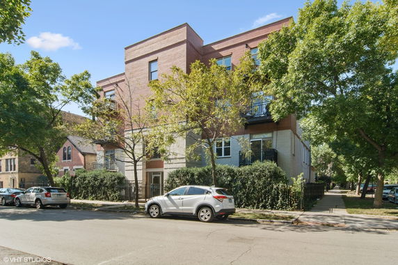 Front view of a multi-story brick building with balconies.