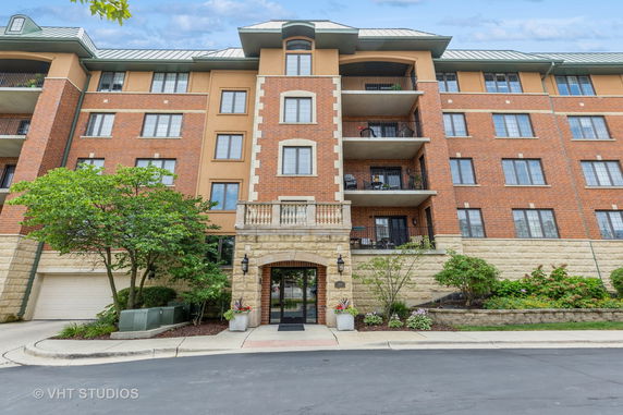 Front view of a multi-story residential building with brick and stone facade.