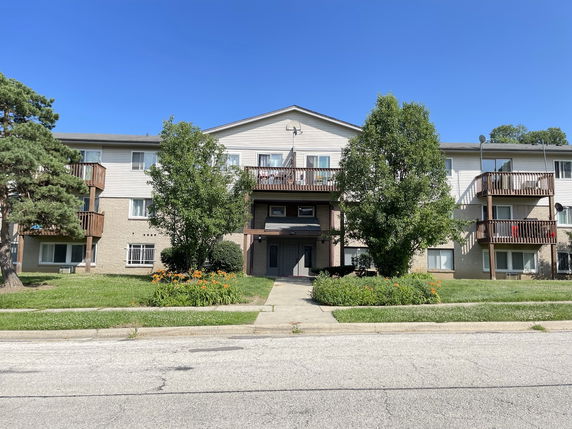 Front view of a multi-story apartment building with balconies.