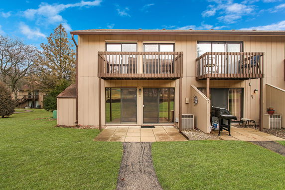 Front view of a two-story house with balconies and sliding glass doors.