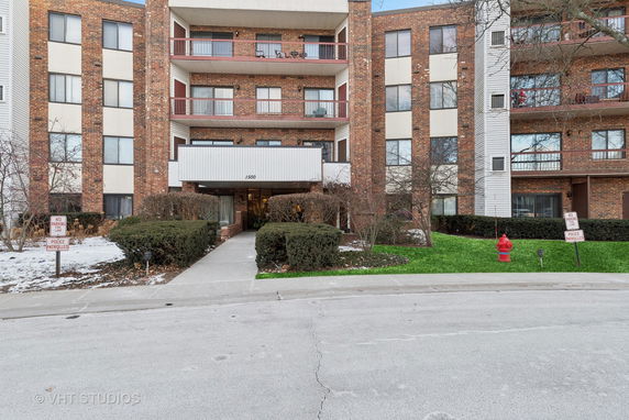 Front view of a multi-story apartment building with a central entrance.