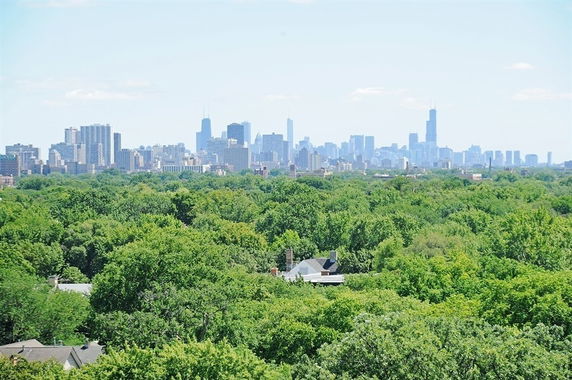 Panoramic view of a city skyline over a vast green landscape