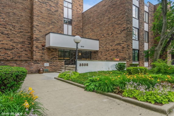 Front view of a brick multi-story building with a glass entrance.